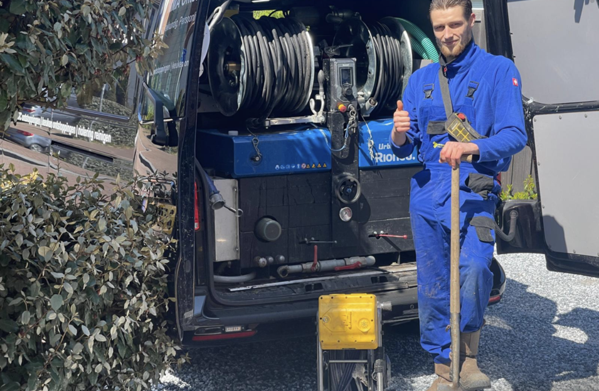 Monteur naast een servicebus met slangen en apparatuur